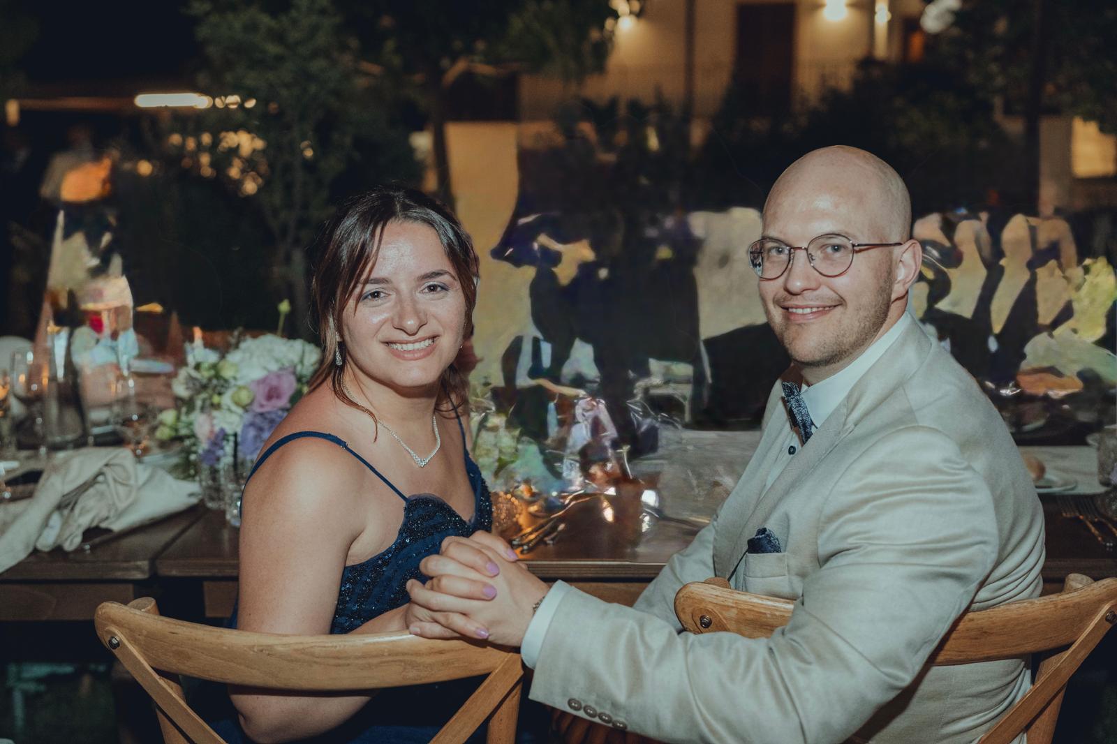 Teona und Thorsten sitzen abends an einer festlich gedeckten Tafel und halten sich an den Händen